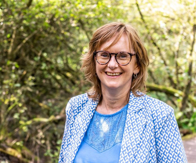 Celest van der Geld lachend in de camera kijkend