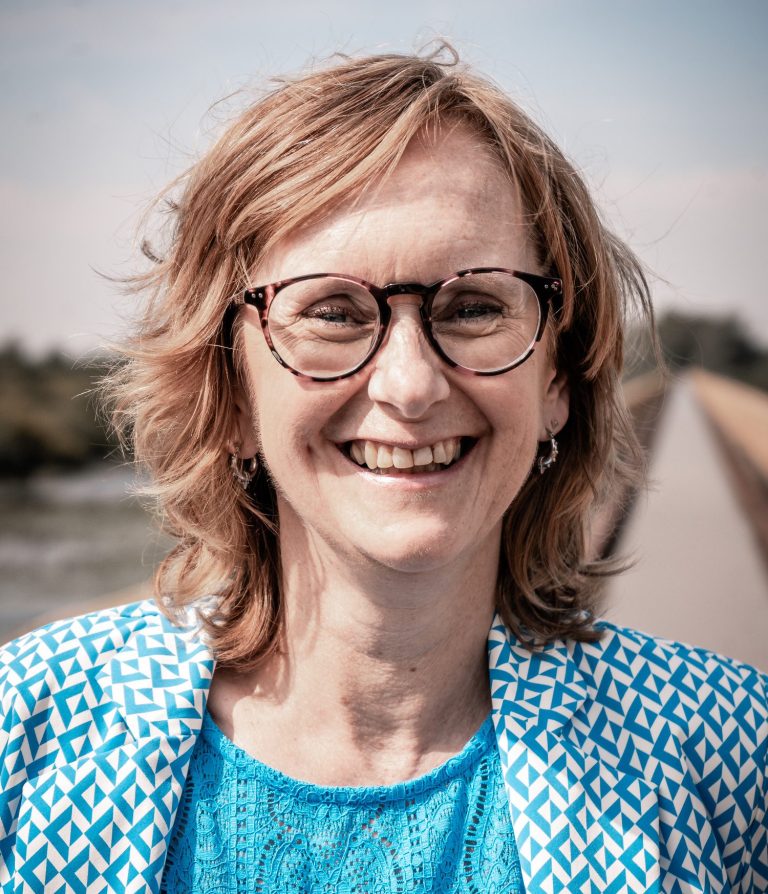 Celest van der Geld lachend in de camera kijkend
